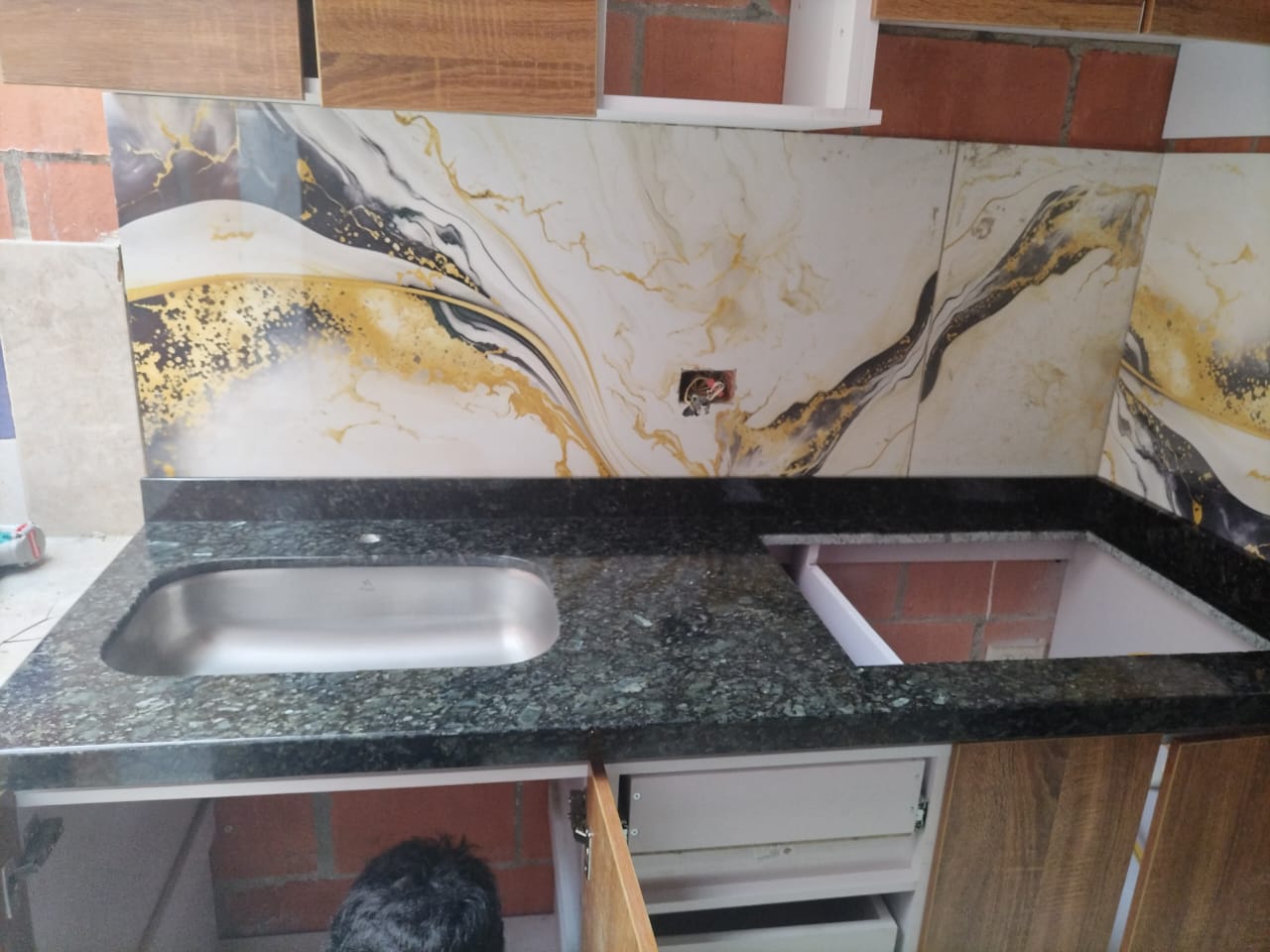Mesón de cocina con backsplash verde y dorado