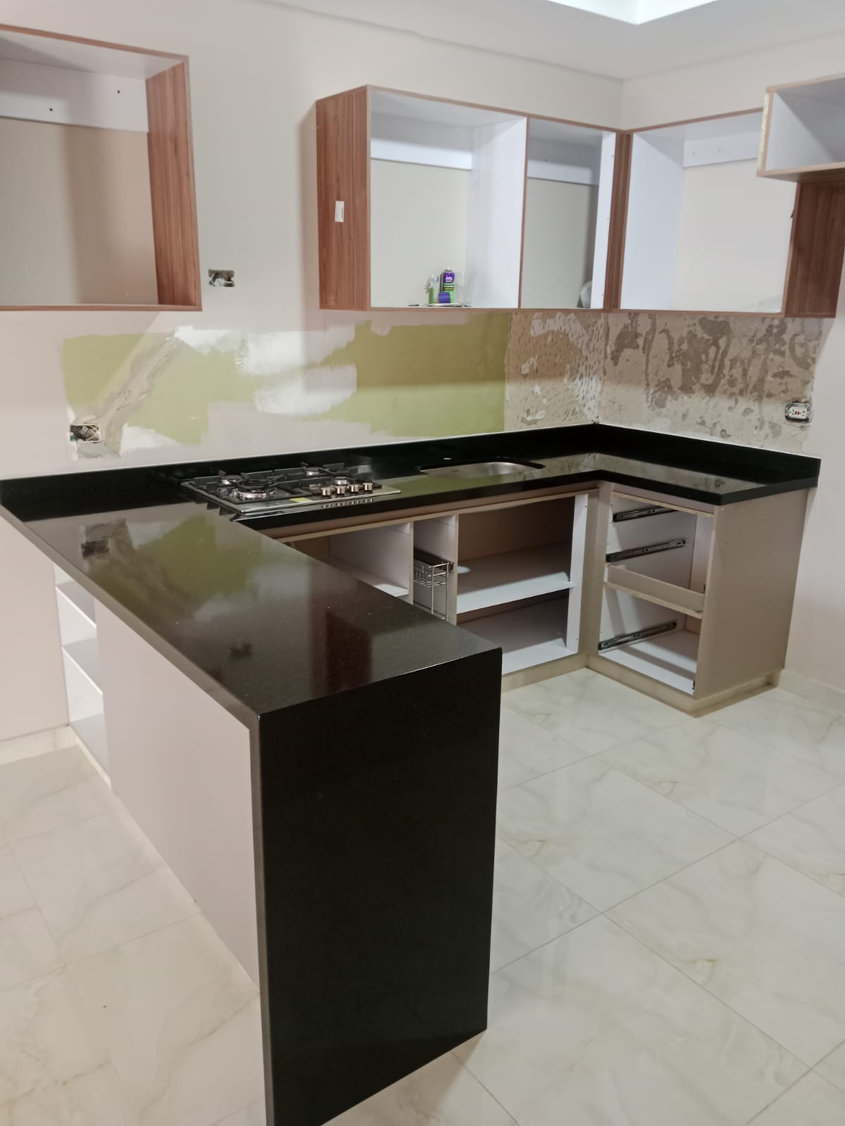 Cocina en L con mesón negro y ventana